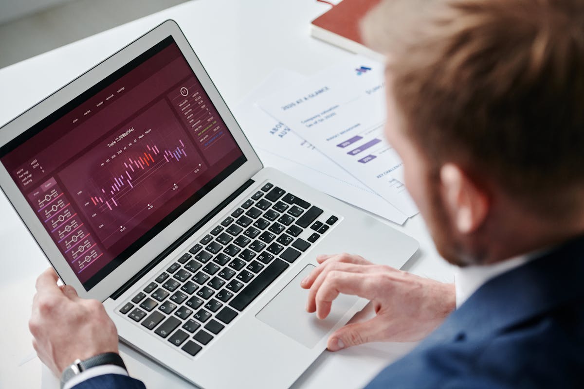 Business professional reviewing data analytics dashboard on laptop in bright office