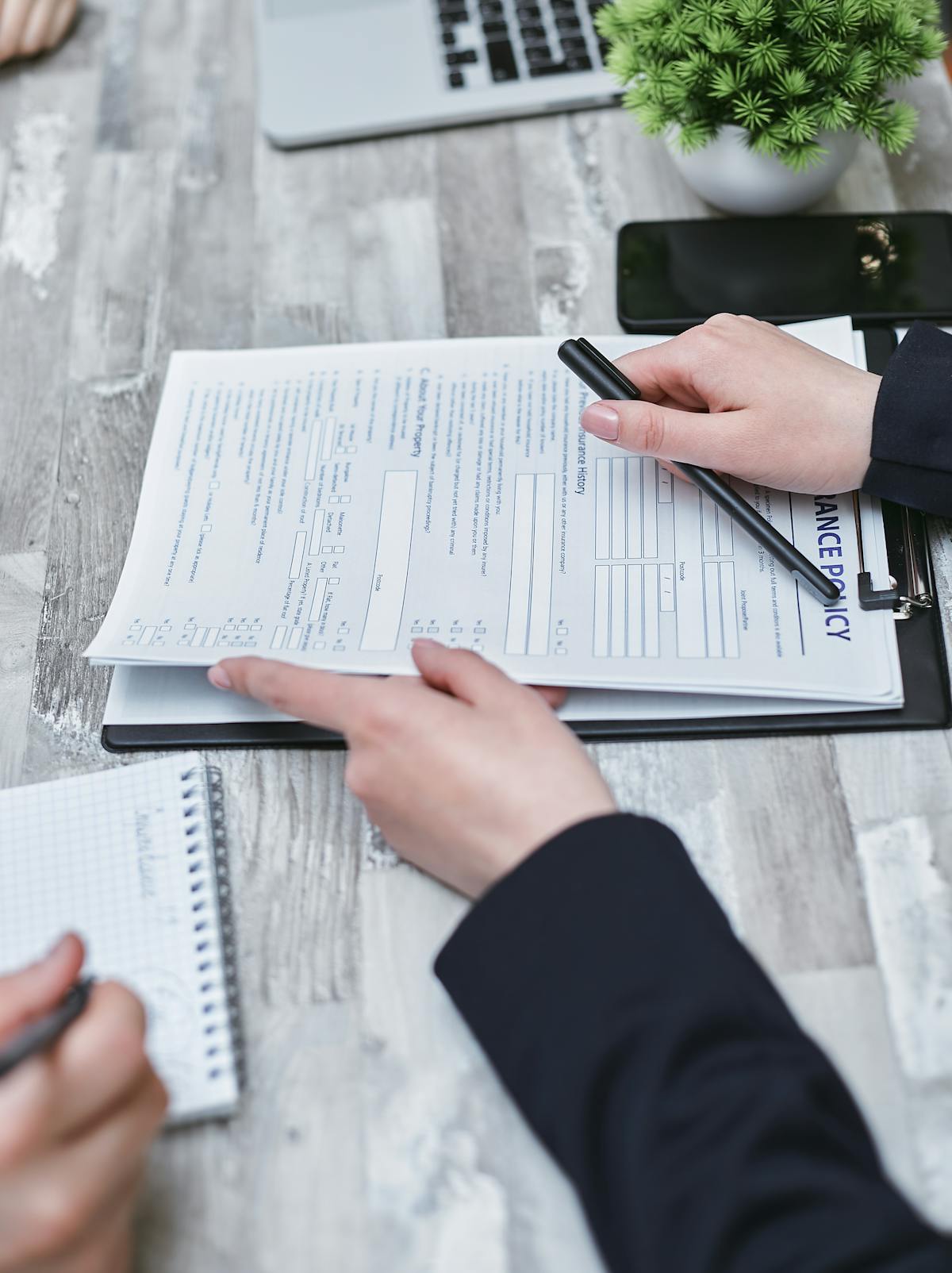 Close-up of hands analyzing professional documents, representing careful compliance review